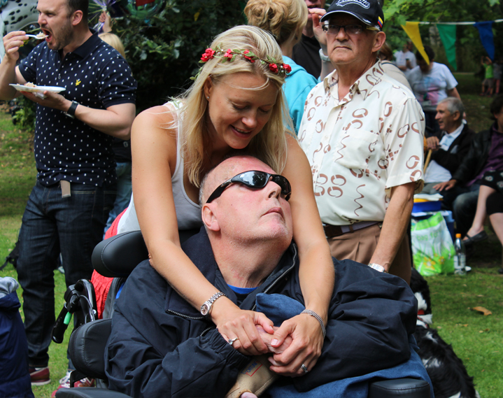 Neal (in a wheelchair), held so tightly by Sarah, his carer and wife.