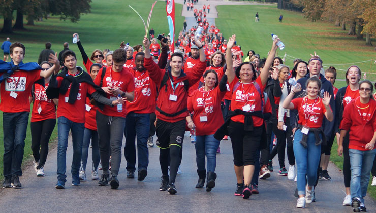 The Brain Tumour Charity team and volunteers wearing red shirts walking down a road.