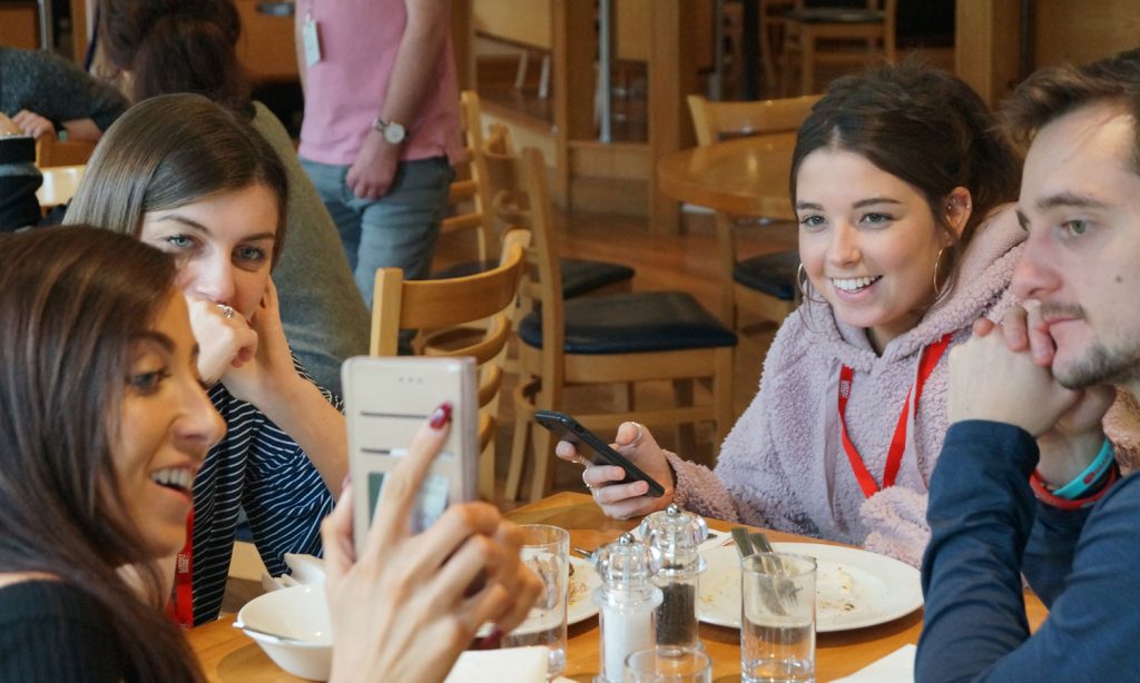 A group of young adults enjoy lunch together at one of The Brain Tumour Charity's Young Adult Meet Ups for people aged 16-30 who are affected by a brain tumour diagnosis.