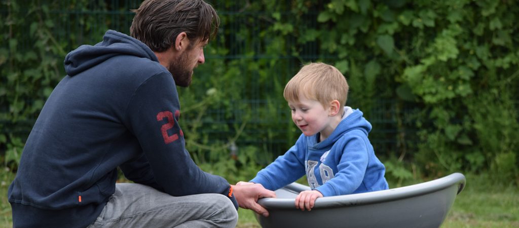 A father and son laugh as they play together at one of The Brain Tumour Charity's Family Days.