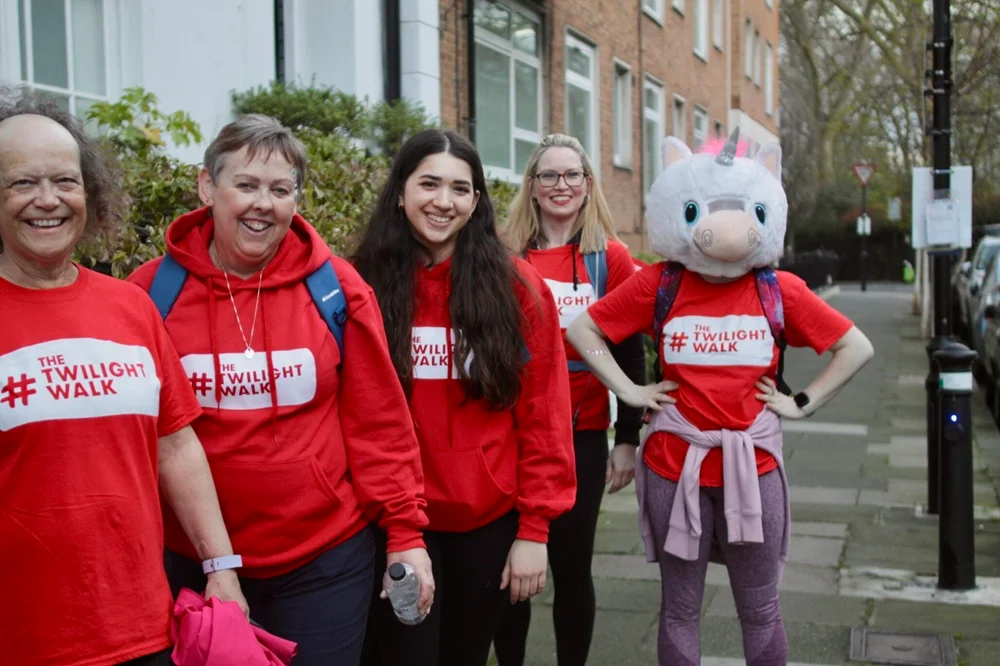 People on a London street wearing red The Twilight walk t-shirts