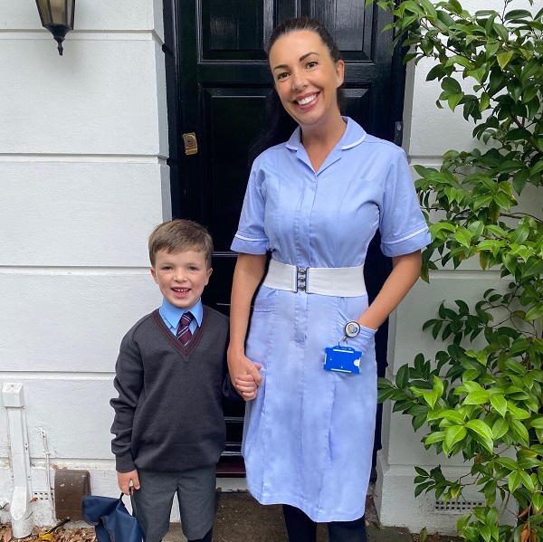 Kate became a neuro nurse after her brain tumour diagnosis, here she stands in her nurse's uniform holding hands with her son