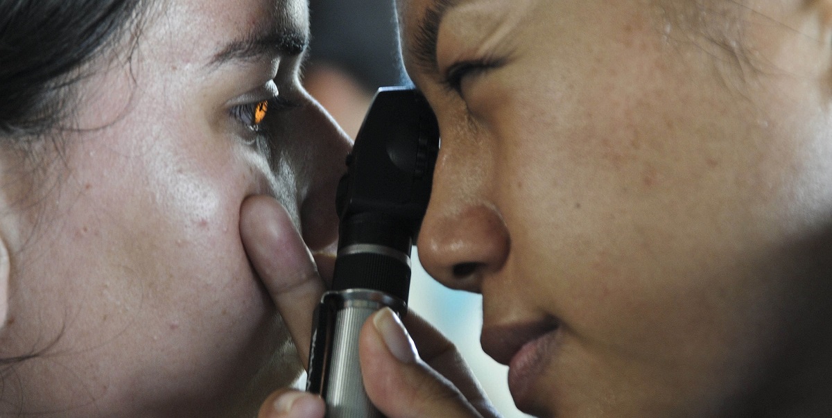 optician doing an eye test looking for a brain tumour