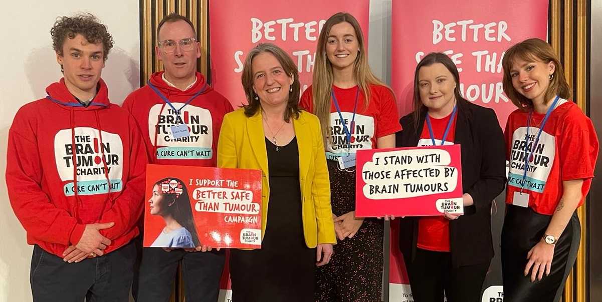 The Brain Tumour Charity volunteers smiling as they visit Scottish Parliament to promote Better Safe Than Tumour - an awareness campaign for the signs and symptoms of brain tumours