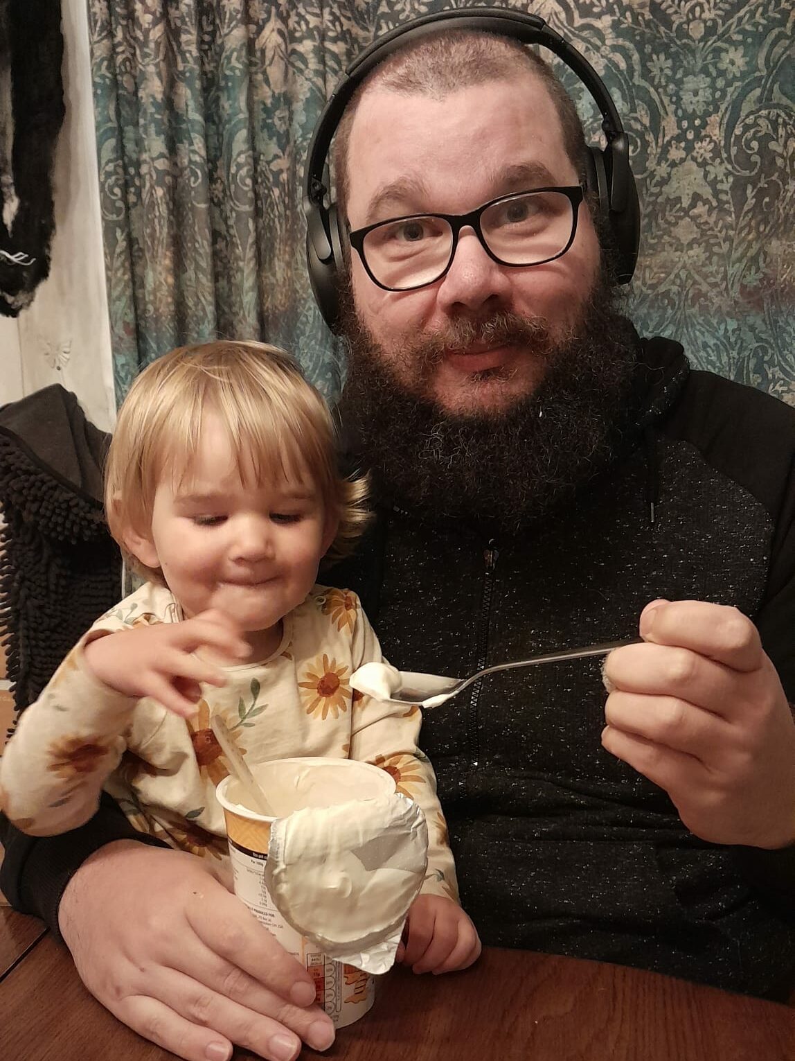 Jerome van Leeuwen, who is wearing noise cancelling headphones, feeds his daughter, Abi