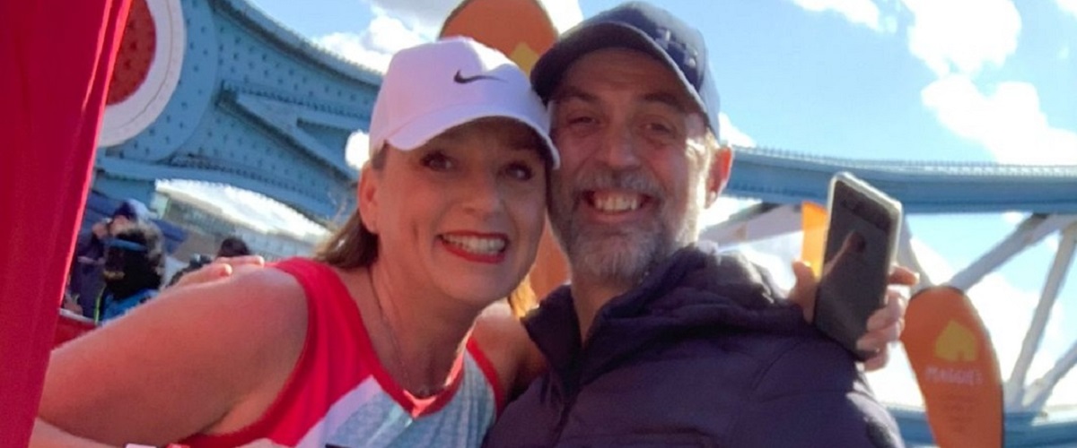 John and Rachel smiling as Rachel wears a running vest from The Brain Tumour Charity