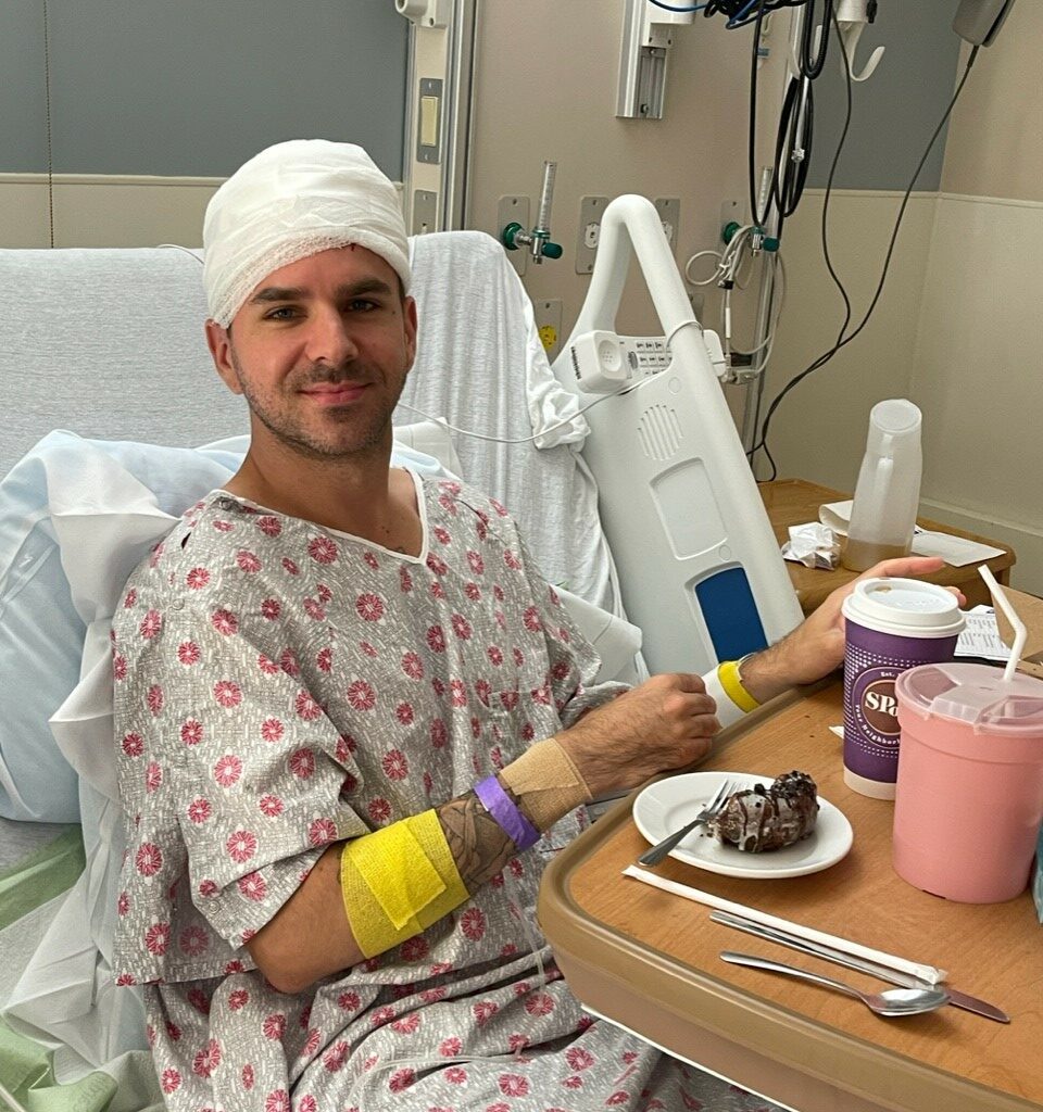 Musician Josh in a hospital bed following surgery for a brain tumour