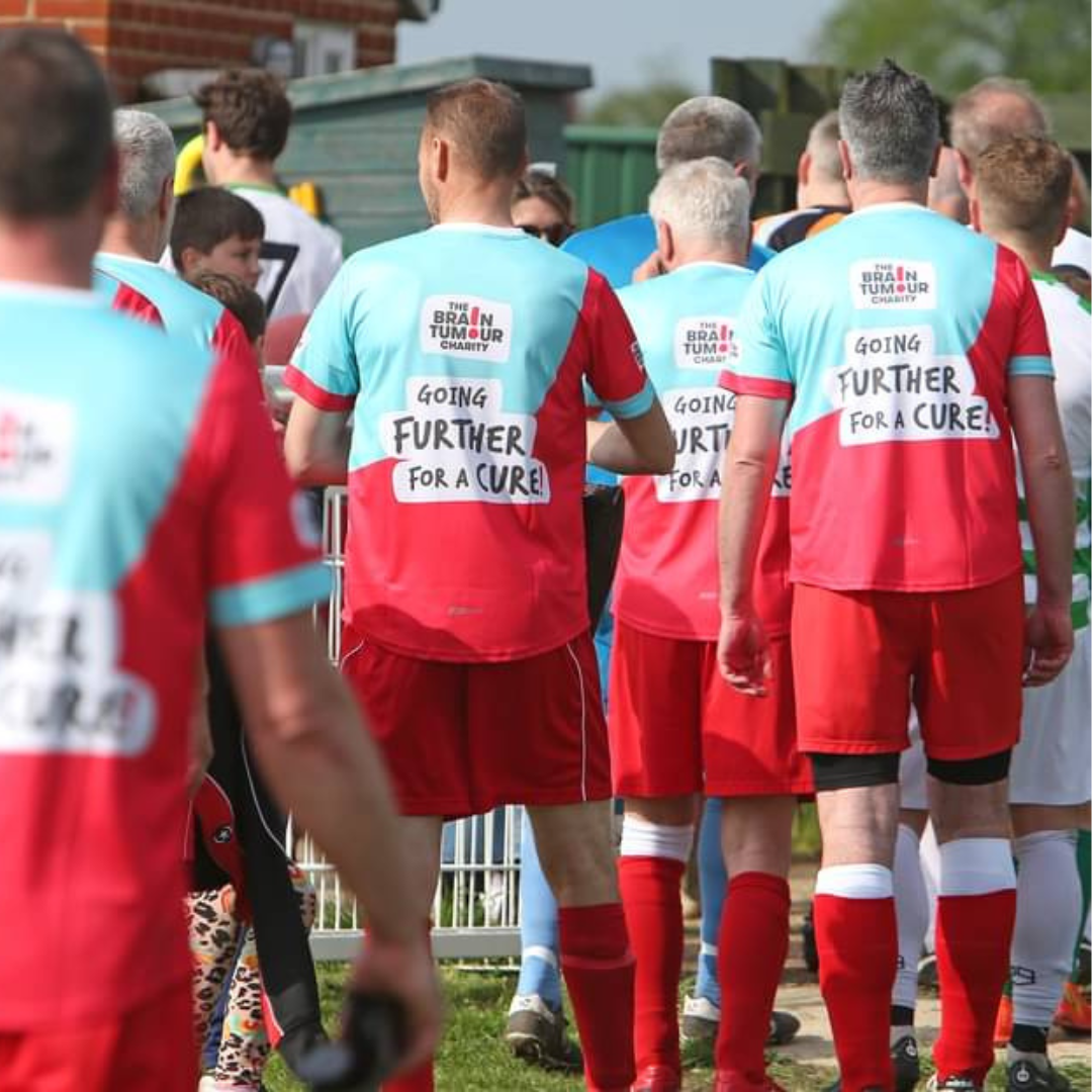 Players walking away from the camera in their The Brain Tumour Charity play shirts as they leave the field.