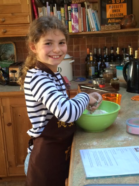 Lizzie Bramall mixing the ingredients together for a cake. Lizzie was diagnosed with a diffuse midline glioma when she was 9, but she continued her love for baking.