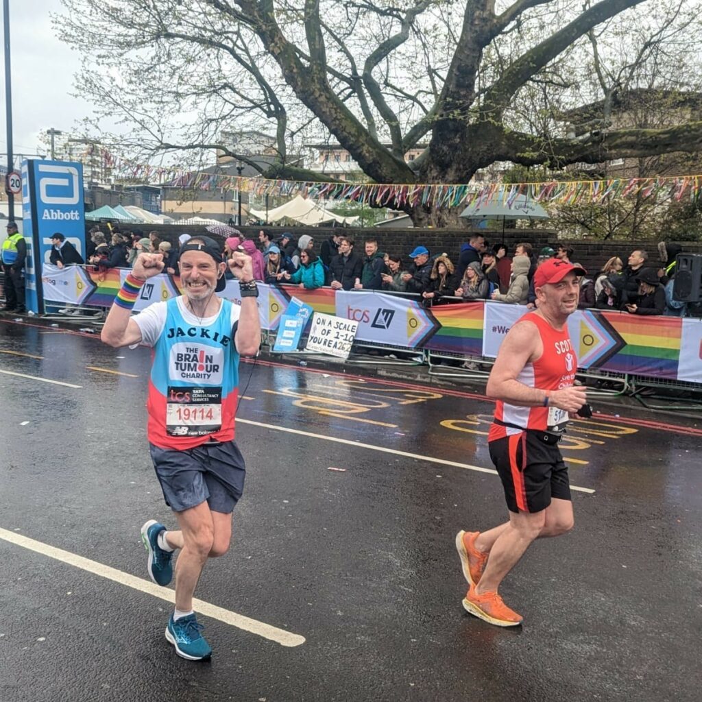 Adam's running whilst smiling and celebrating with his arms in the air.