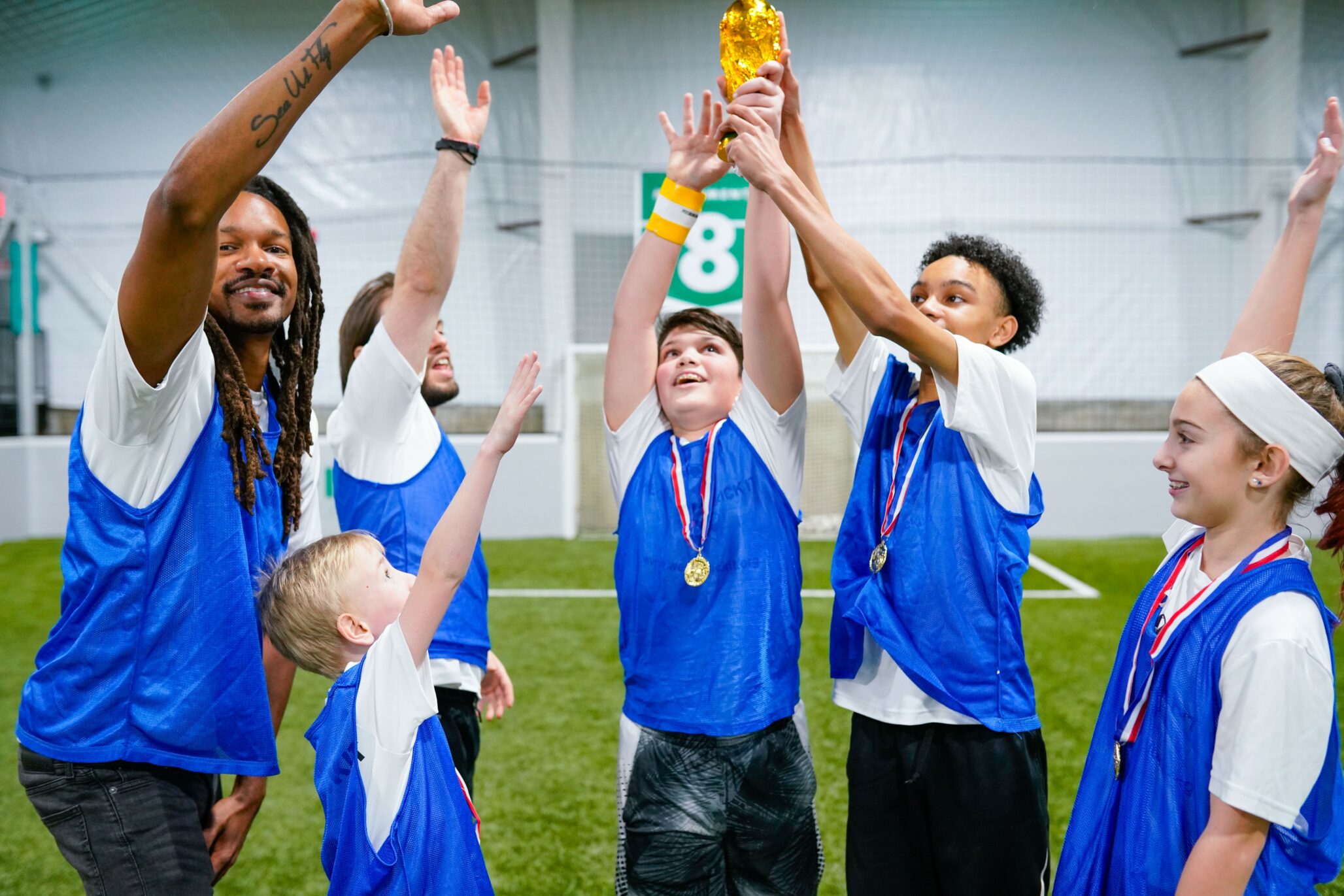 A children's football team holds up a trophy