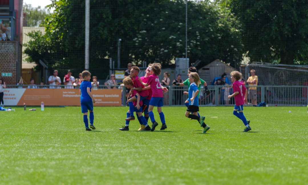 Children cheering at charity football event