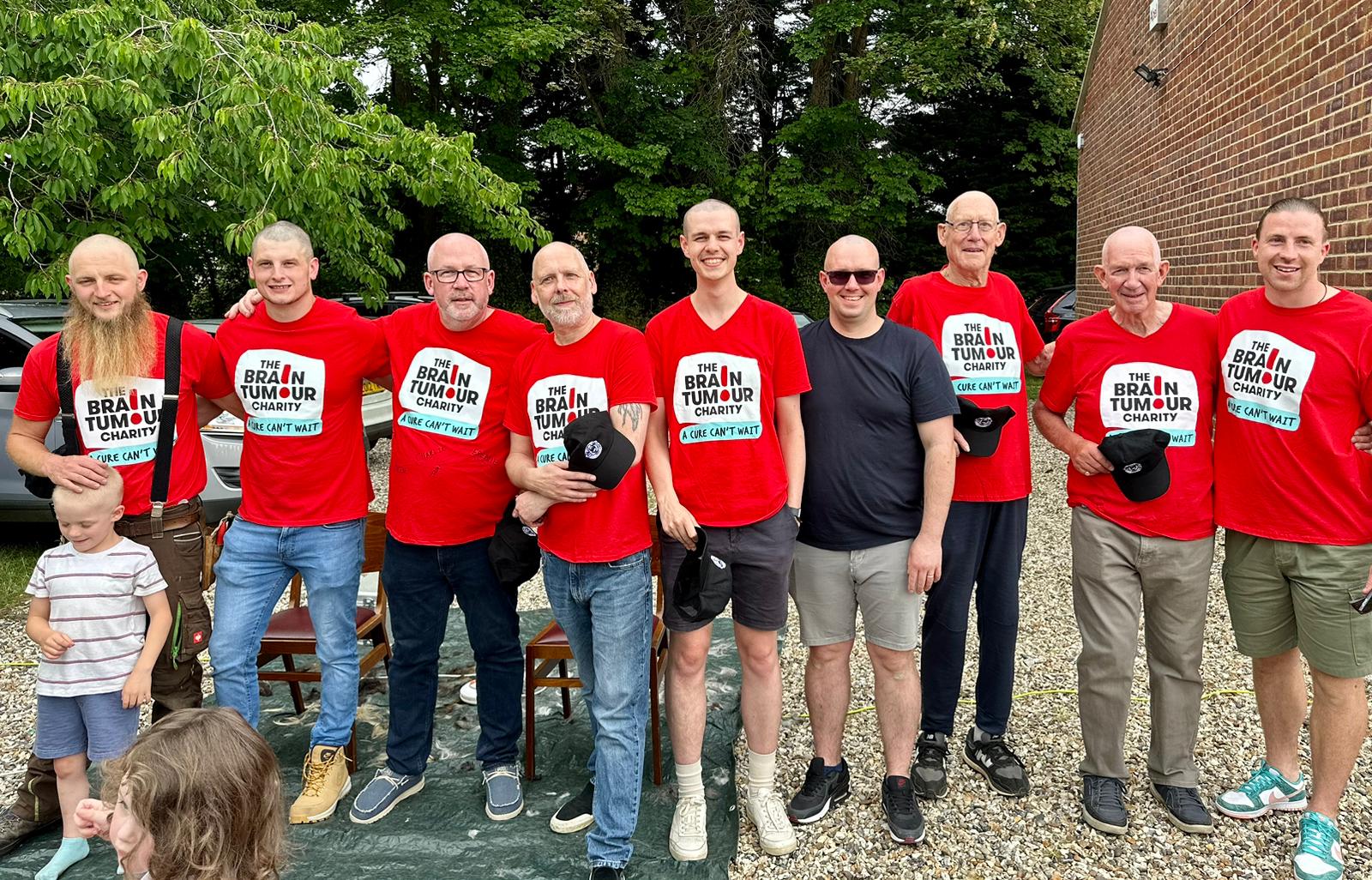 The nine people who braved the shave smile after they have had their heads shaved