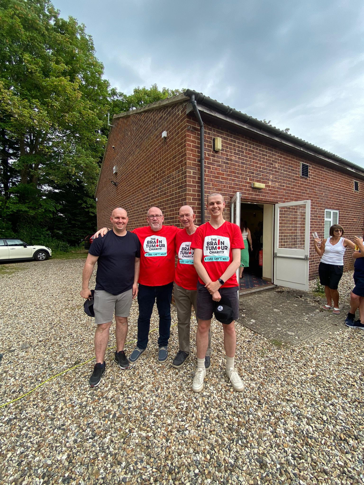 Four men smile as they enjoy a Fun Day to raise awareness of brain tumours