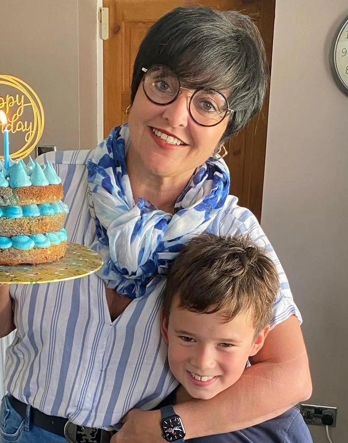 A mother with her arm around her son smiles after learning how to write a Will in the UK