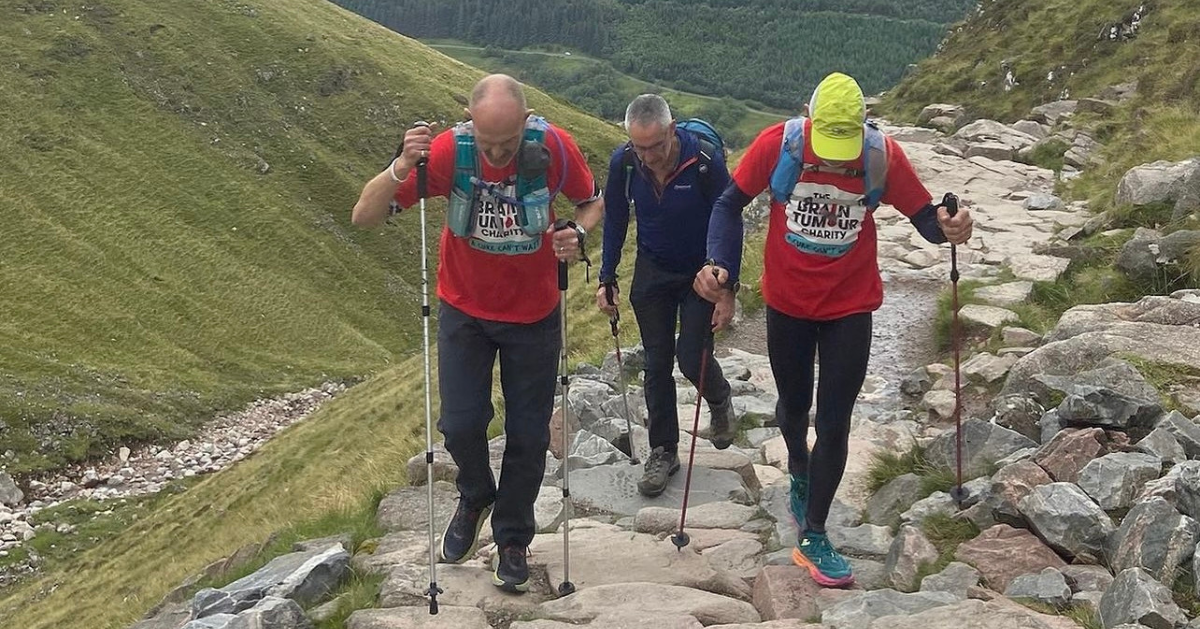 Two men wearing The Brain Tumour Charity t-shirts take on one of the peaks in the Three Peaks Challenge