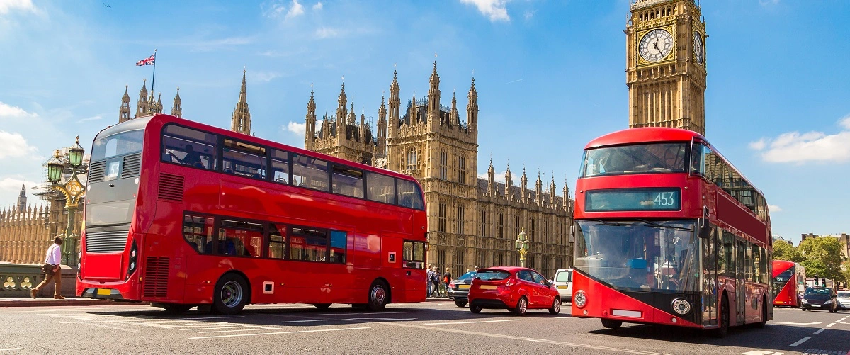 London busses driving past the Houses of Parliament and Big Ben