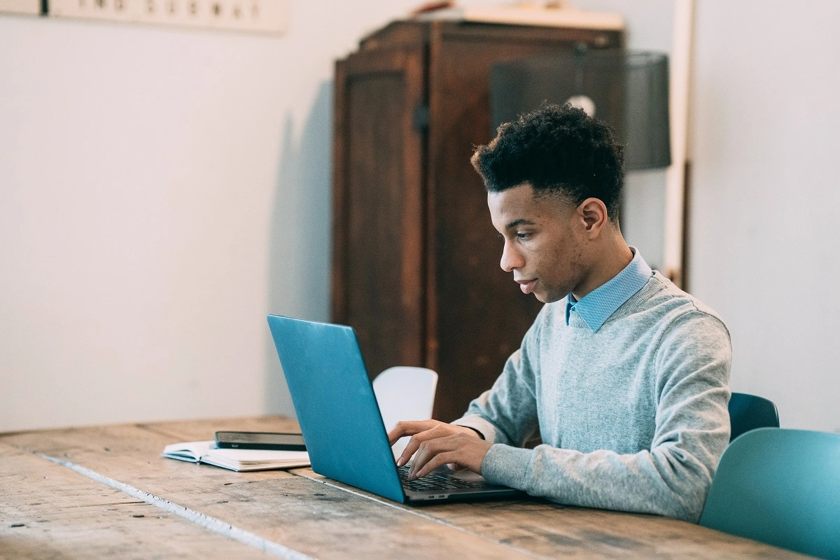 a man sits at a computer researching how to write a Will for free