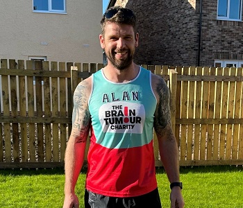 Alan posing in his charity running vest