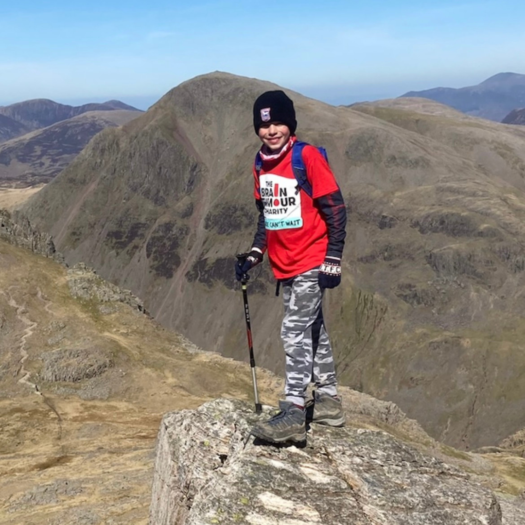 Harry Smith climbing Scafell Pike in his red The Brain Tumour Charity T-shirt.