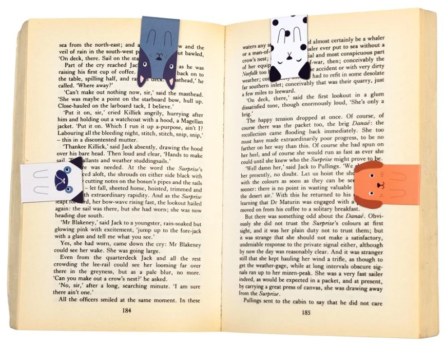 Magnetic dog bookmarks clasped onto the pages of a book