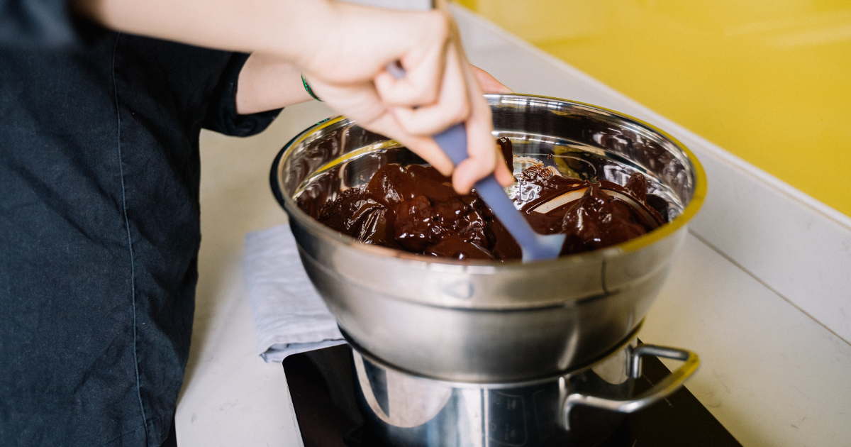 Hand stirring raspberry ruffles in a pot 