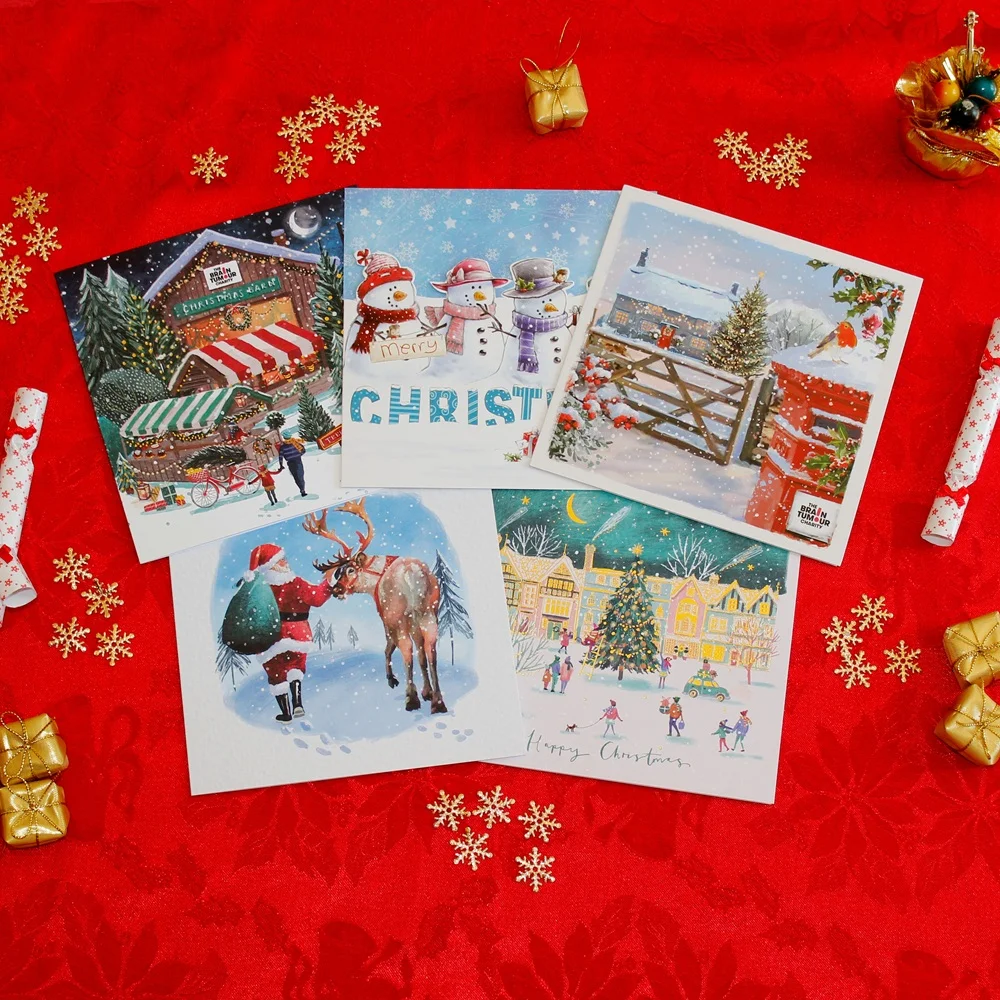 A collection of The Brain Tumour Charity Christmas cards on a red background