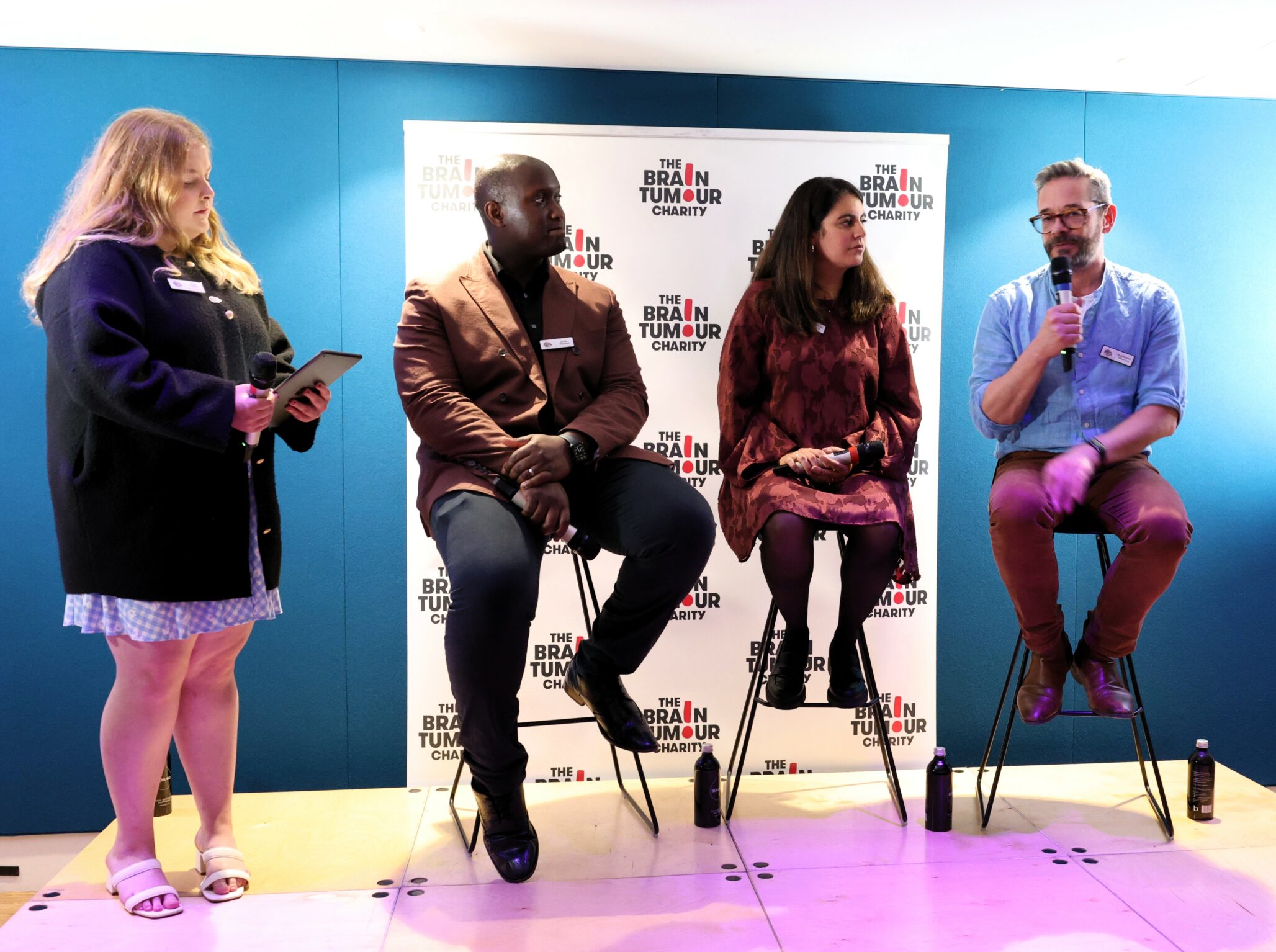 Molly Fenton, standing, next to three researchers involved in a question and answer session