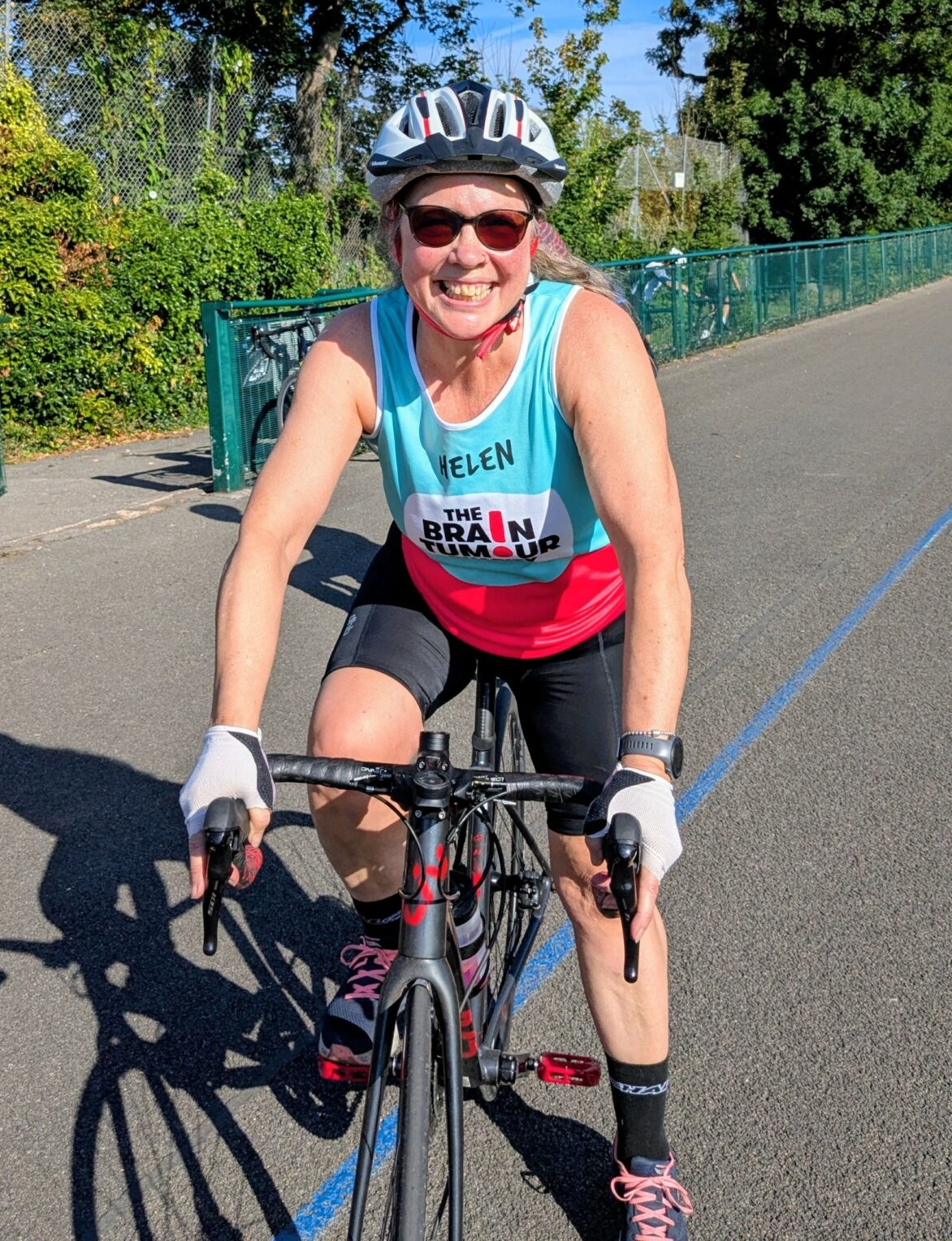 Helen on her bike wearing her charity cycling vest