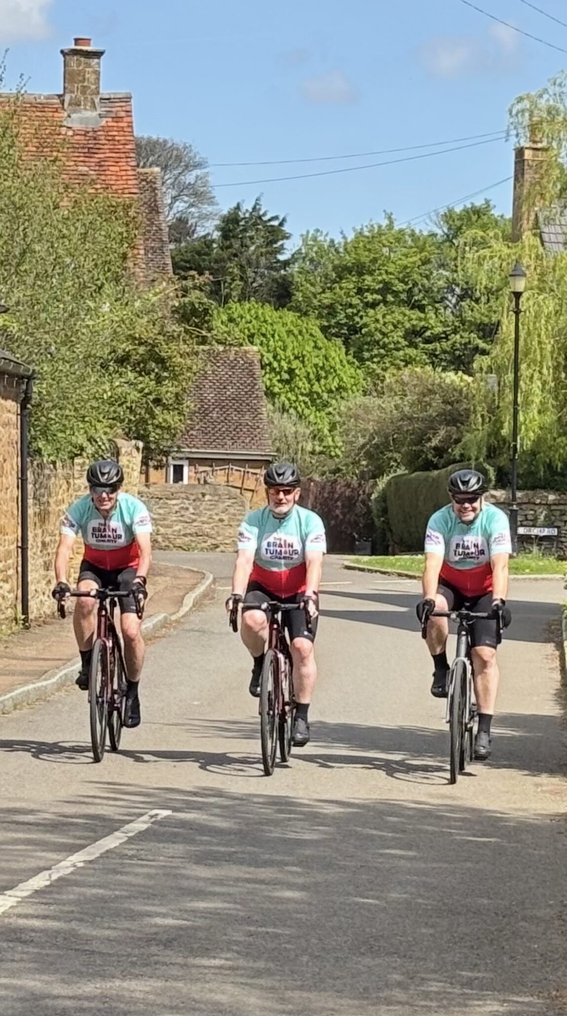 three men on bikes wearing The Brain Tumour Charity jerseys