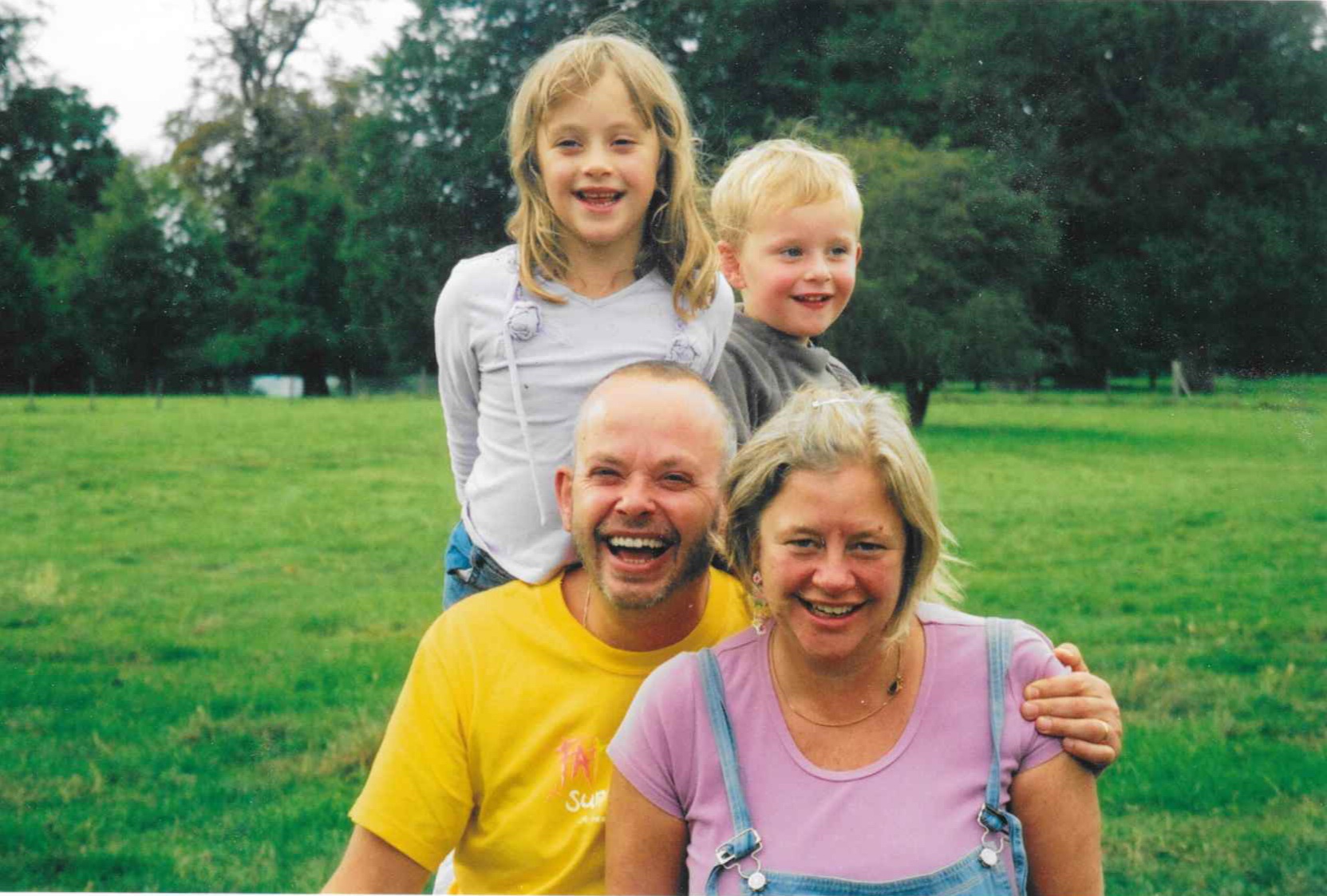 A child picture of Jeremy, with dad Giles, mum Clare, and sister Jess as they sit in a field