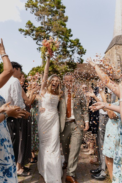 Jeremy and Lottie in a shower of confetti at their wedding
