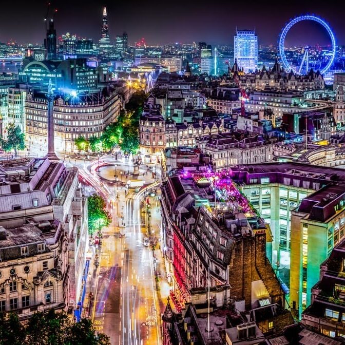London at night with different colour lights highlighting parts of the city
