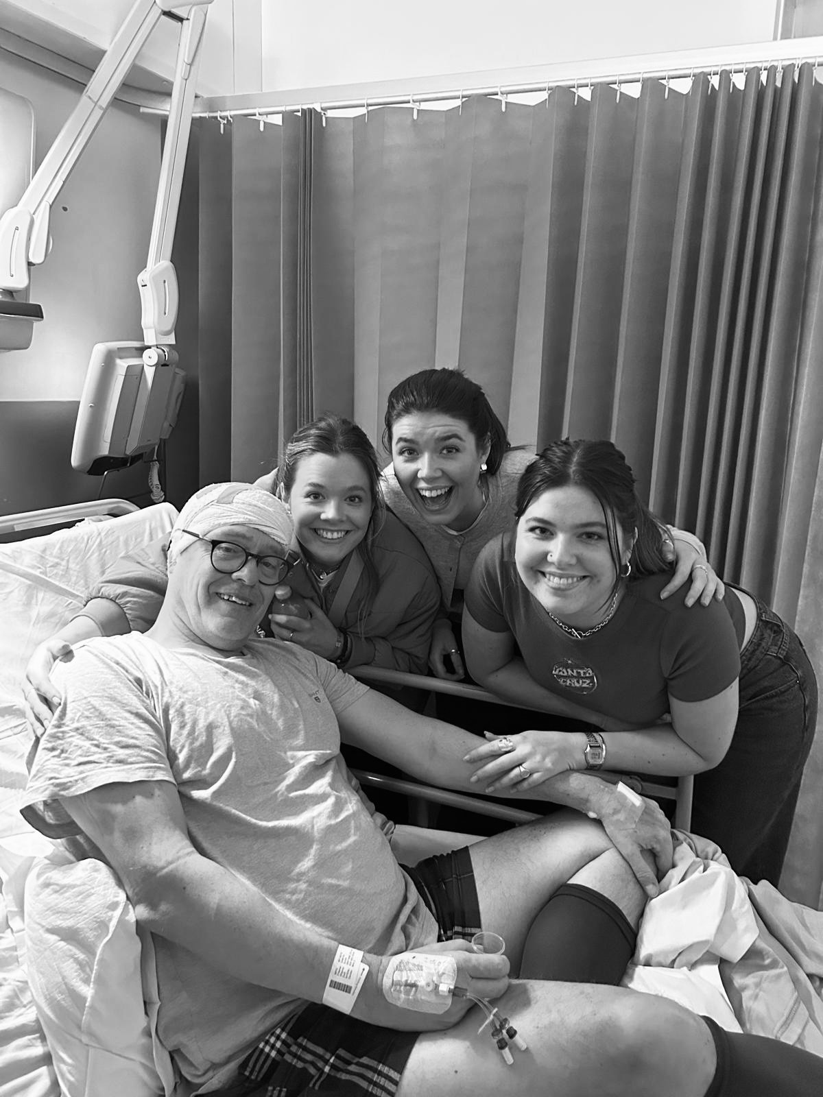 Ellie Smith and family stand around her father's hospital bed