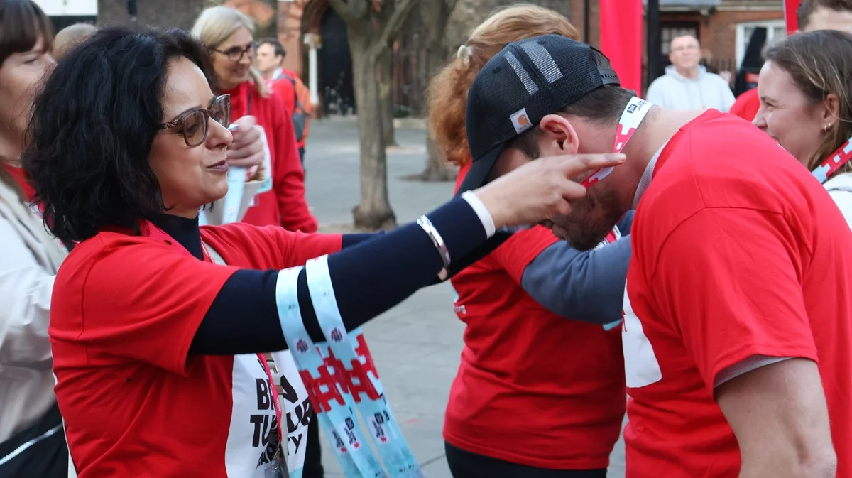 A woman placing a medal on a walker's neck at The Twilight Walk