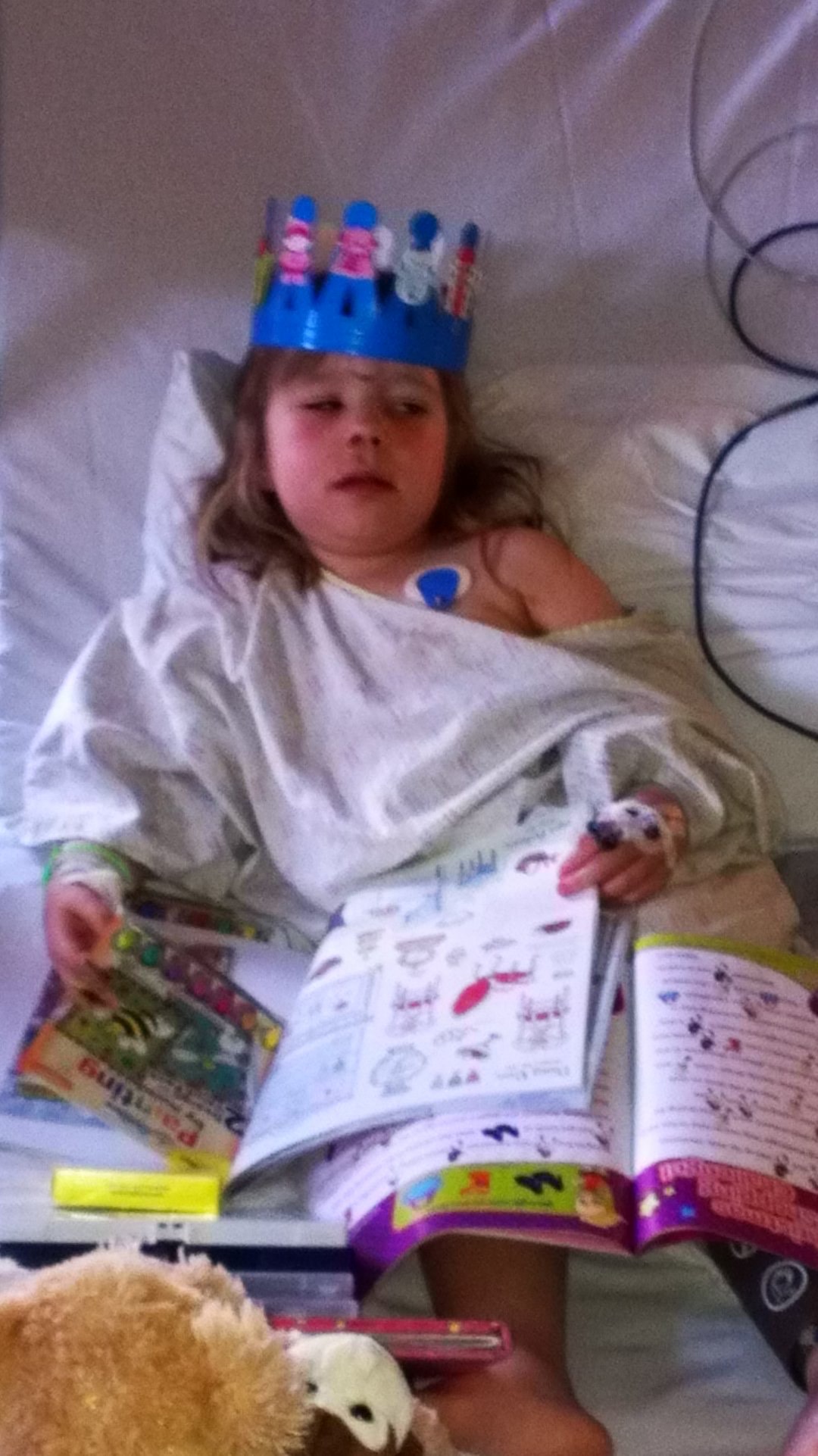 Lily in a hospital bed holding an activity book