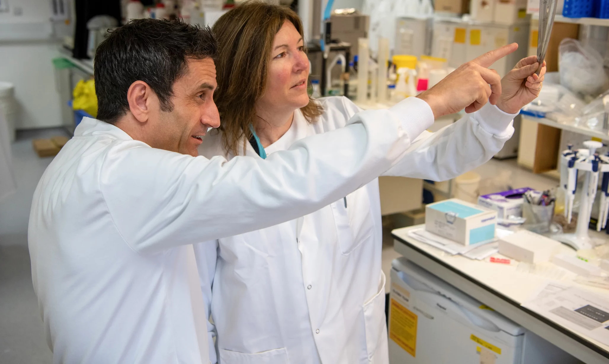 Researchers holding sample readouts