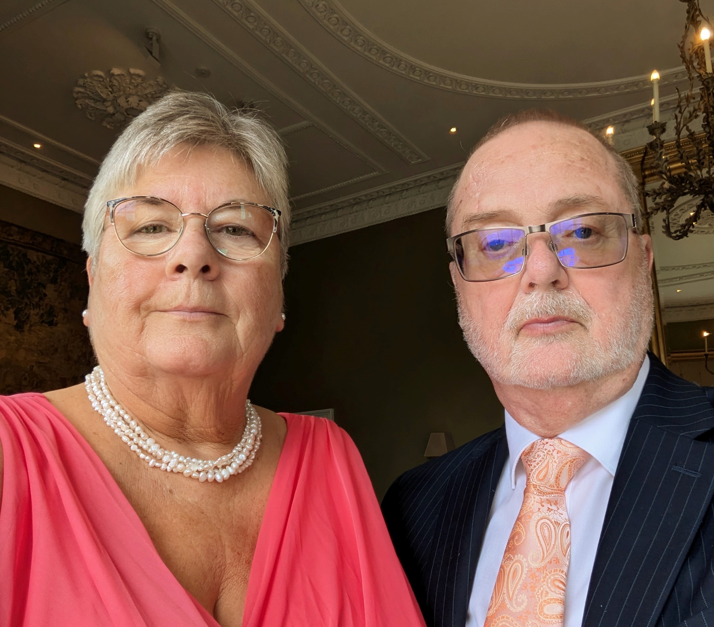 A man and woman in formal wear looking at the camera
