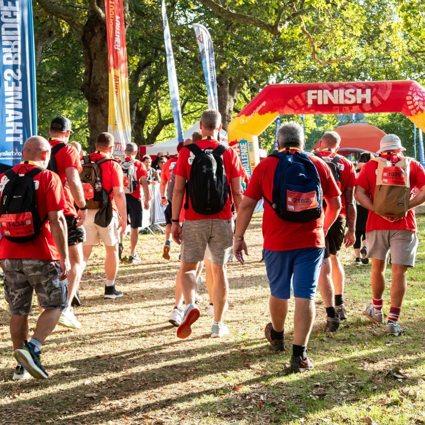 People walking away from the camera towards the finish line of the Thames Bridges Trek