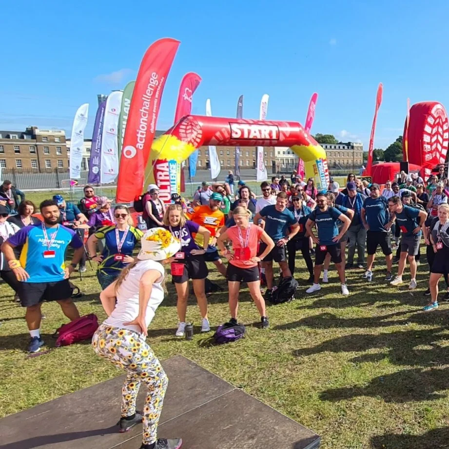 People warming up in a field with a carnival atmosphere at the London Summer Walk