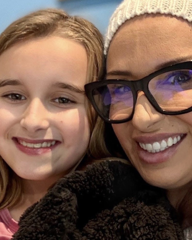 A close-up of Lisa Connell and a young girl, Ruby, smiling at the camera
