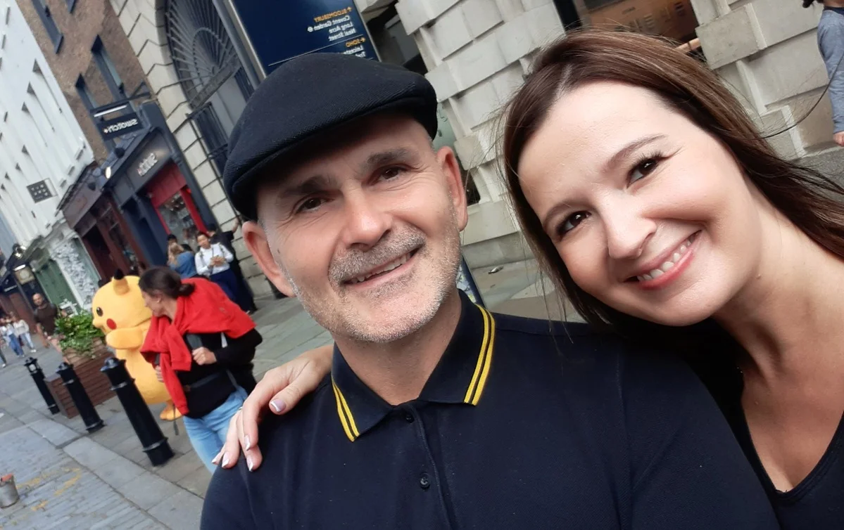 Alex and Claire stand in a city street with a Pikachu figure in the background. They stand to benefit from Expanding Theories research