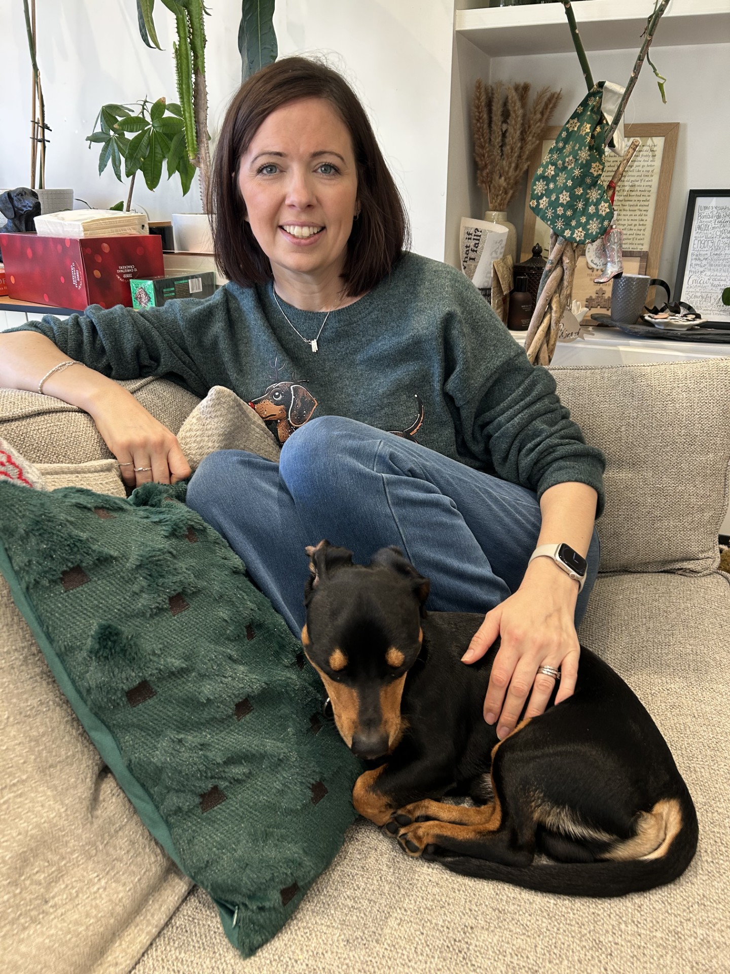 Sally Penny sits on her couch with a dog at her feet. Sally feels that voresidenib has giver her life back.