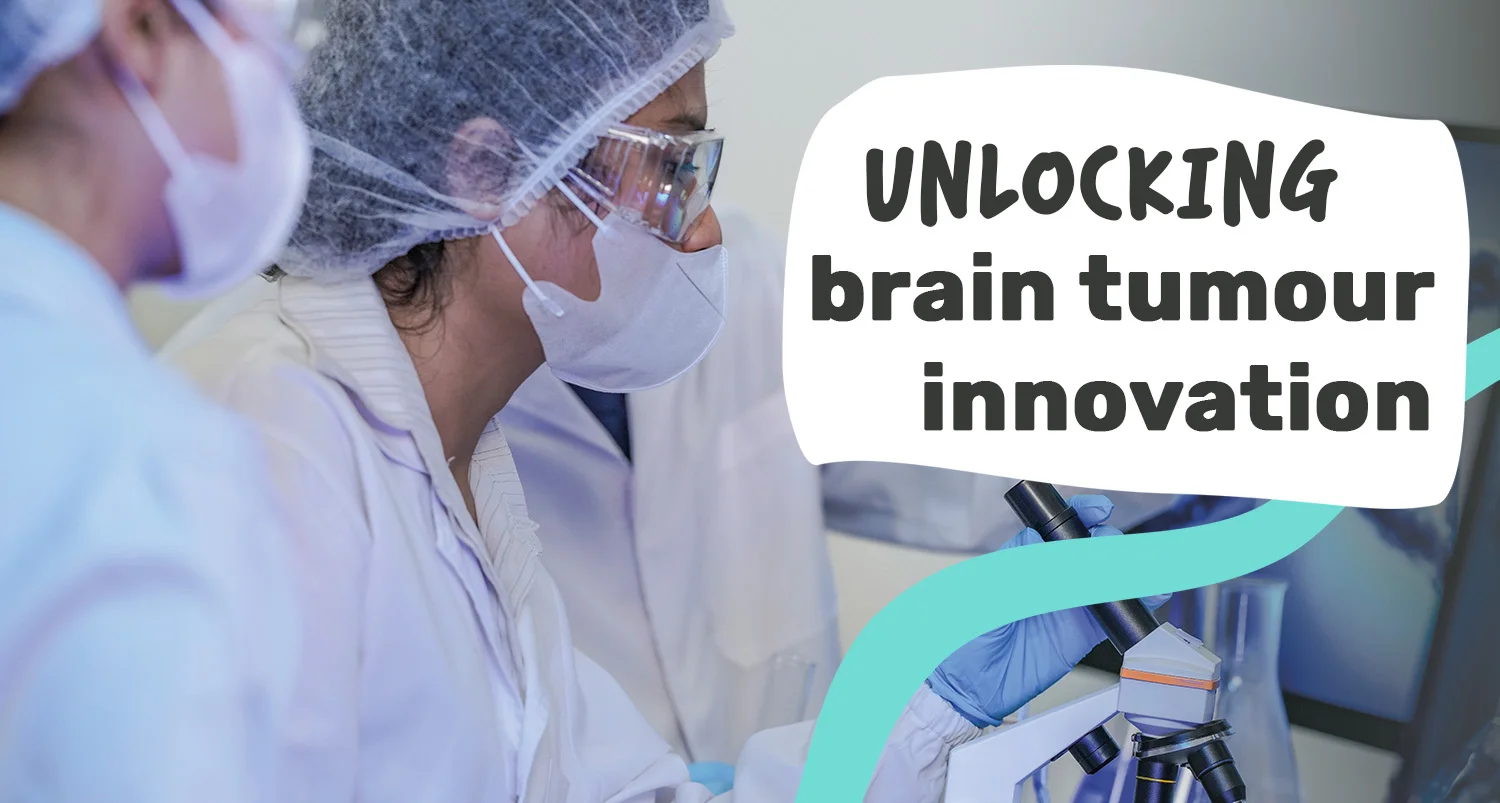 Scientists in face masks and goggles look into a microscope as they work on unlocking brain tumour innovation