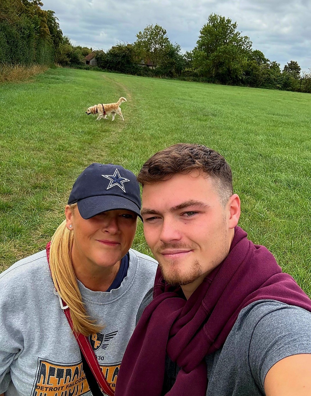 James and his mum walking their dog in the park