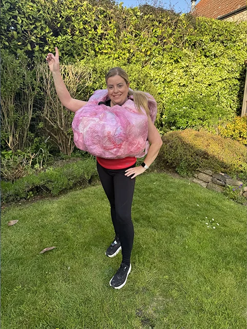 Jane Roberts wears her brain costume while standing in the garden. Jane will run a half marathon dressed as brain to raise funds and awareness