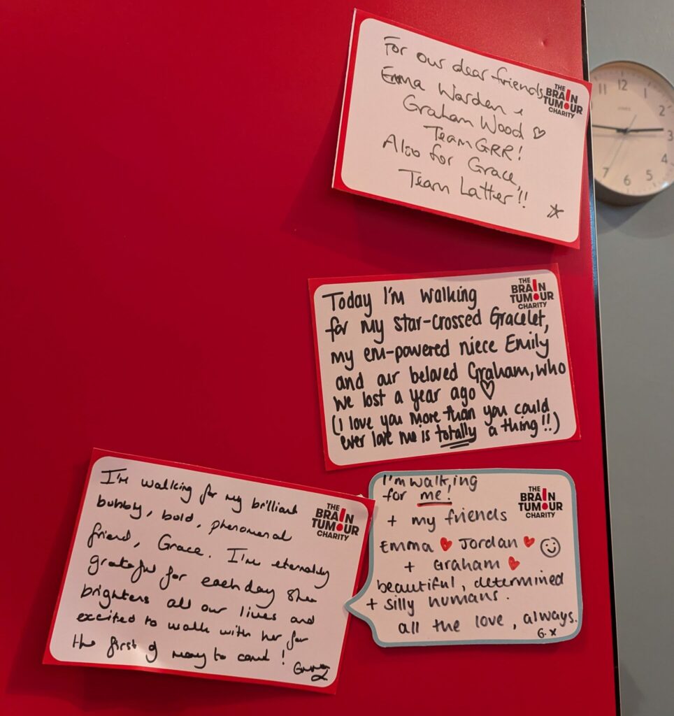 Messages of remembrance, hope and kindness pinned to a red wall