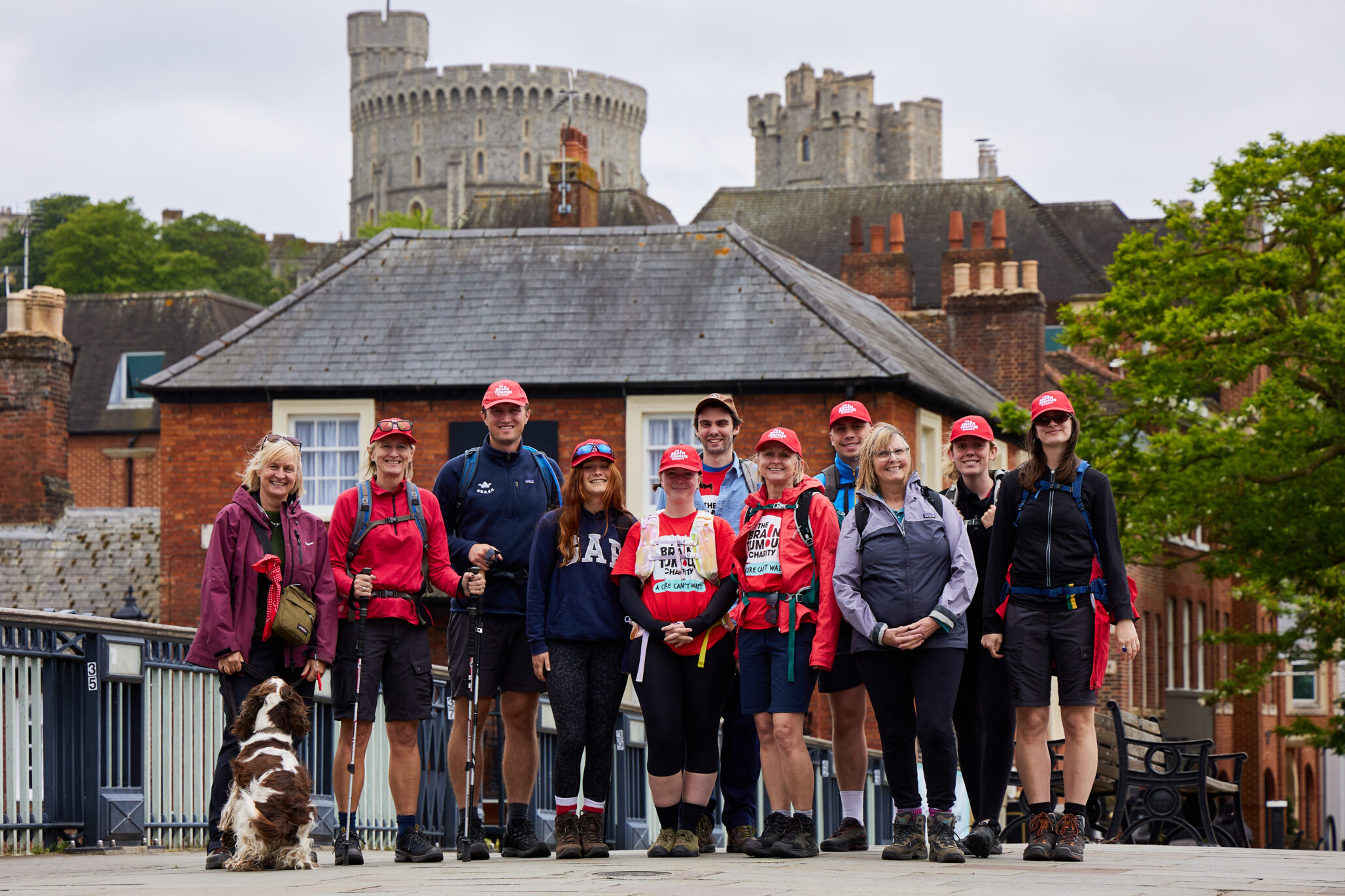 A group of walkers stand with a castle in the background