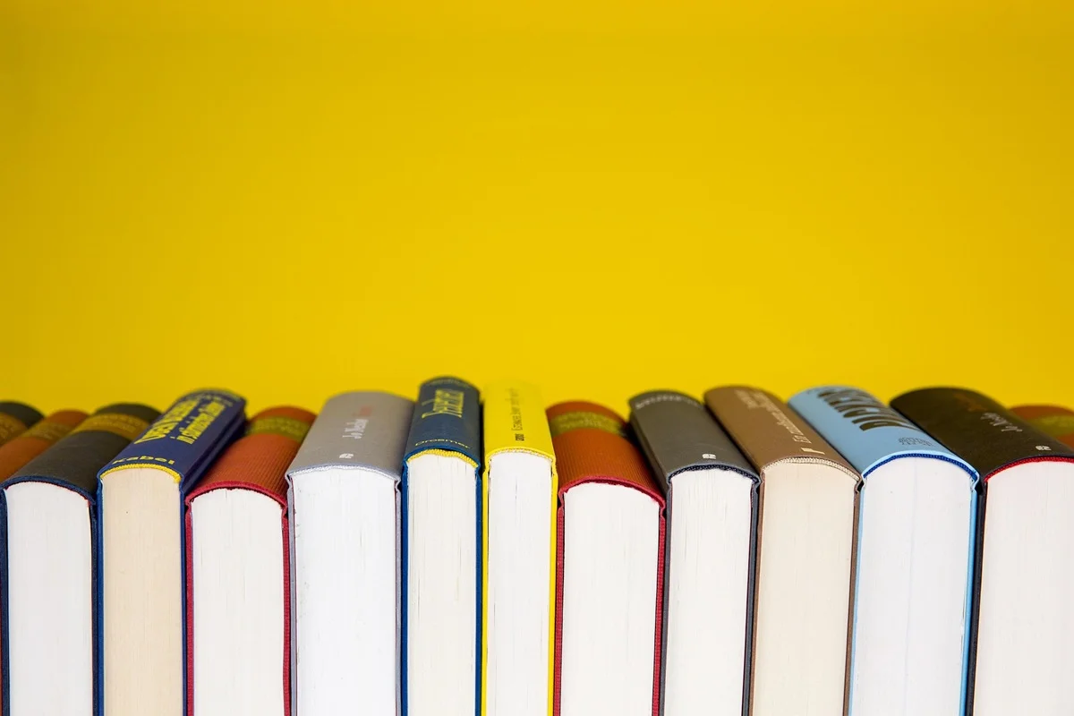 A row of books on a yellow background