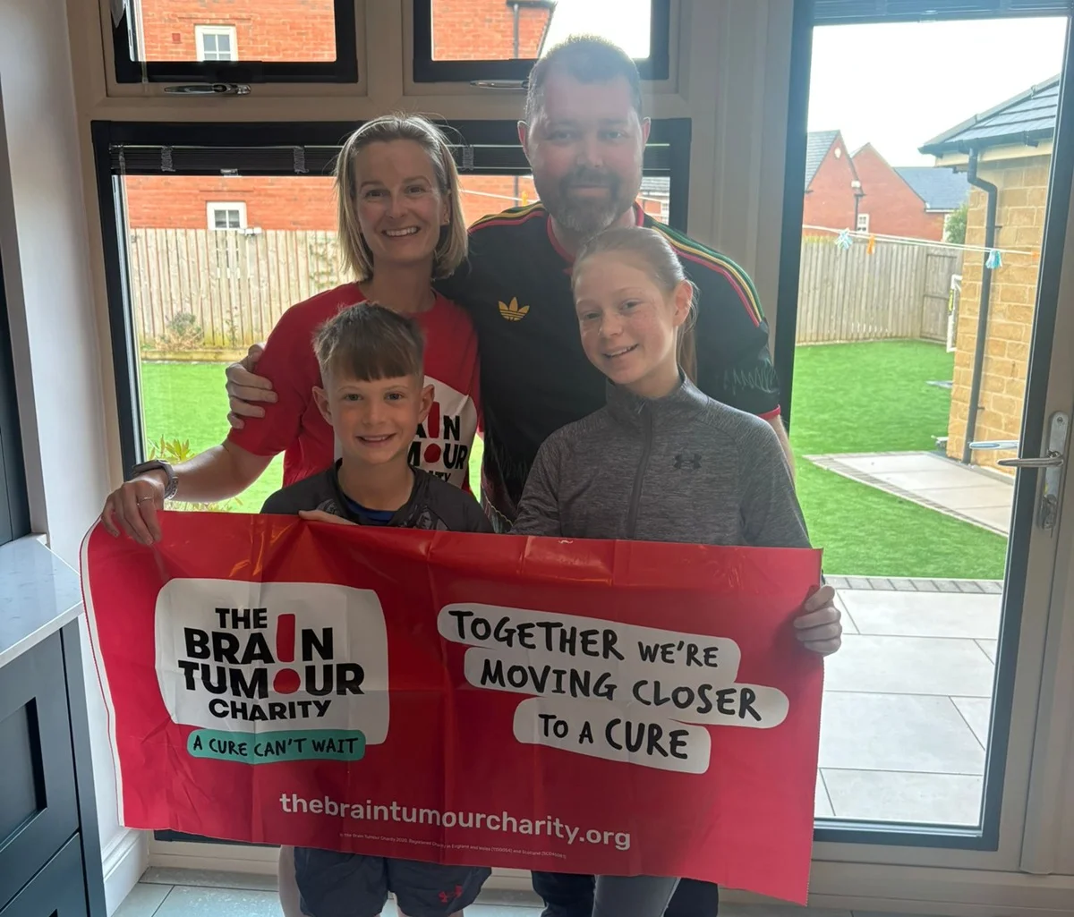 Sarah and family hold The Brain Tumour Charity flag